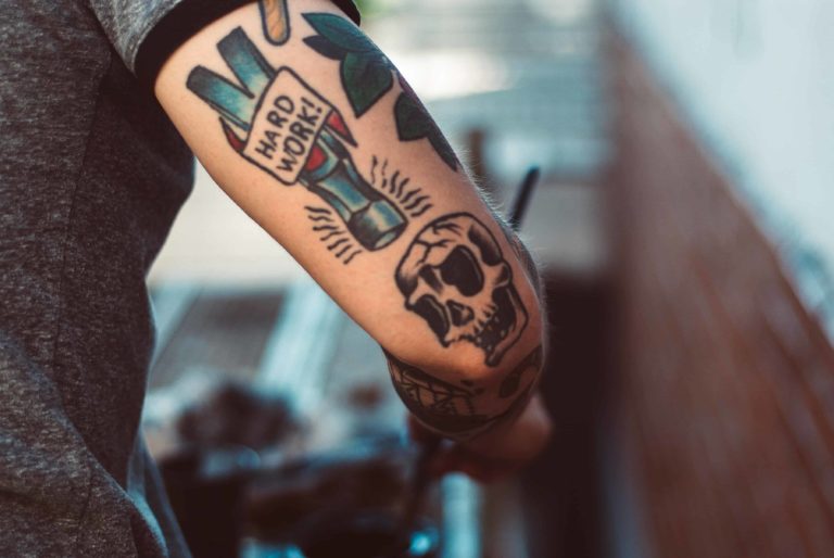Hard Work and skull tattoo on arm